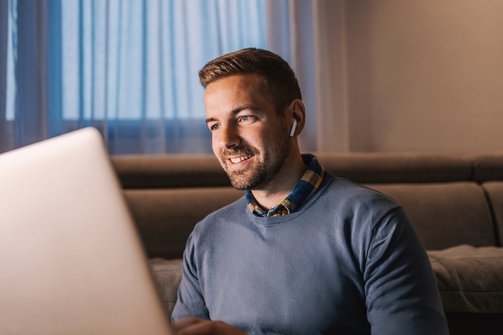 A happy guy sitting and working his remote data entry jobs from the comfort of his home