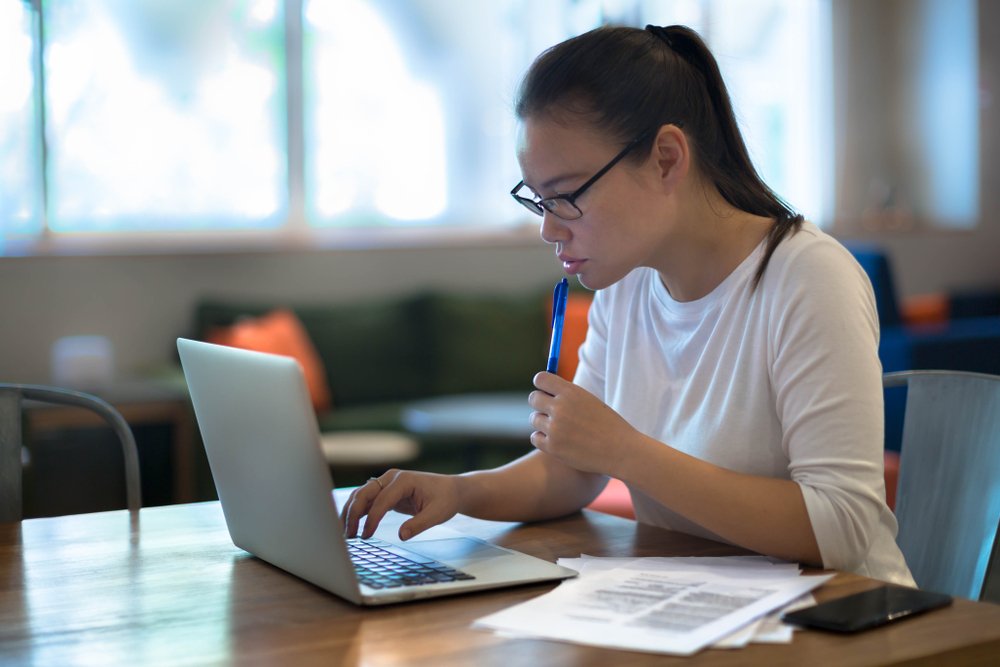 female worker working on her laptop from home, answering the question; Can a Paralegal Work from Home