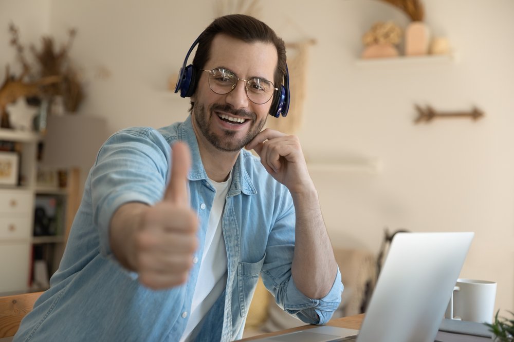 Remote job networking strategies: Portrait of a smiling young businessman in wireless earphones