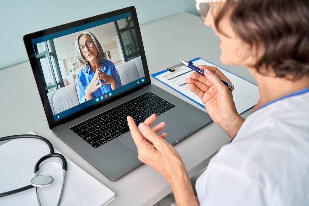 Remote Medical Coding Jobs: Female doctor therapist consulting older senior patients via virtual video call visit using laptop computer. 