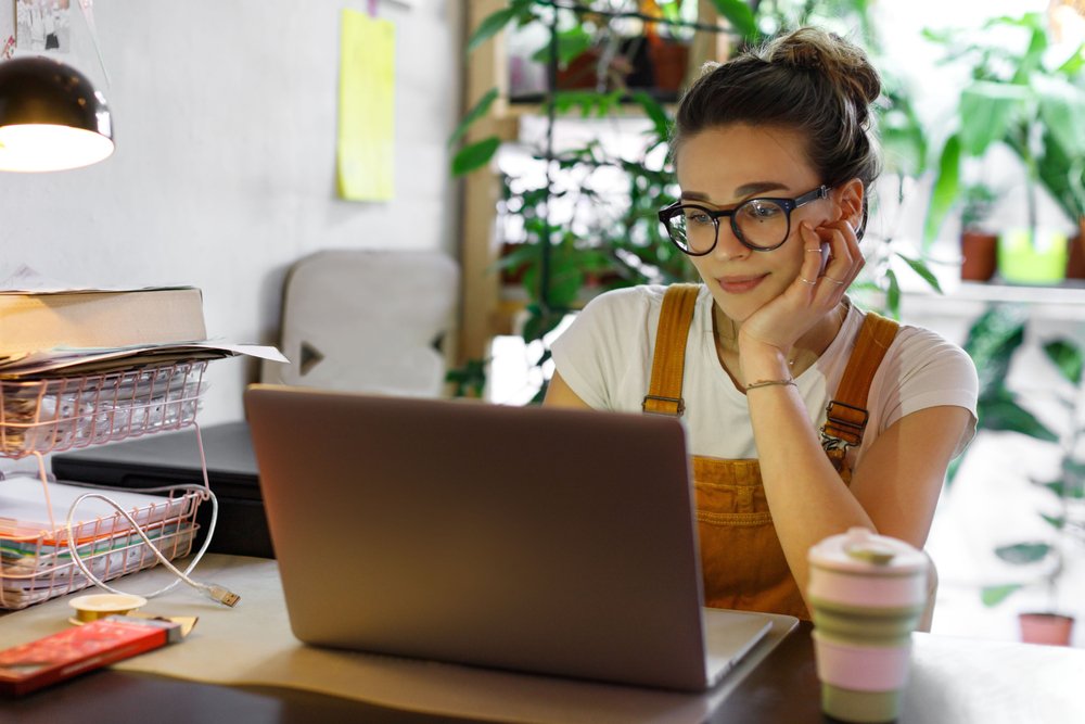 Freelance vs. Employee Remote Jobs: A picture of a female freelancer working remotely from home. 