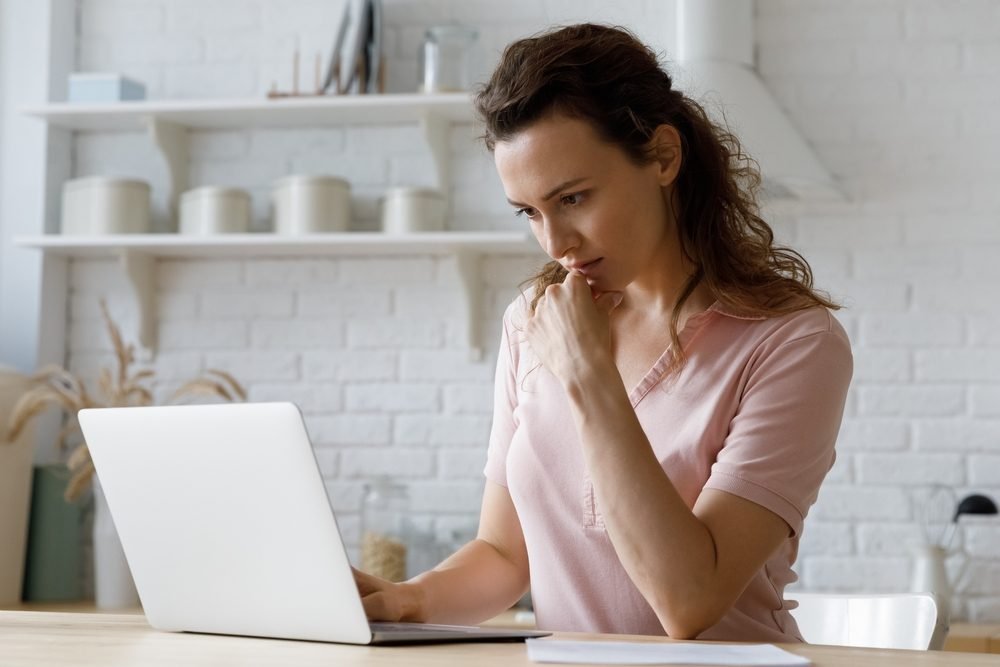 A lady sitting with her laptop, finding remote jobs.