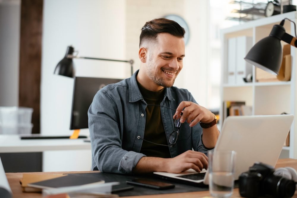 Remote Jobs: Picture of a young handsome man working remotely from home office