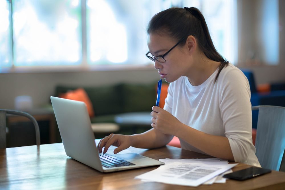 female worker working on her laptop from home, answering the question; Can a Paralegal Work from Home