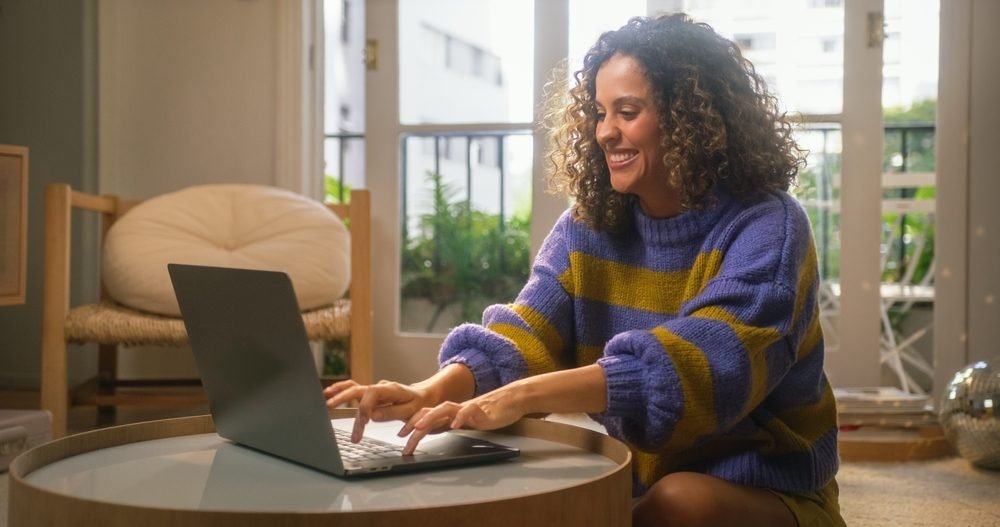 The Best and Worst Aspects of Remote Work: Picture of a smiling lady working from home on a laptop